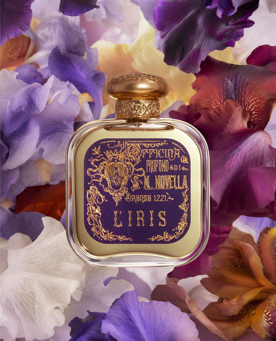 Close-up of a Santa Maria Novella L'Iris perfume bottle on a bed of white, purple, and burgundy iris flower petals.