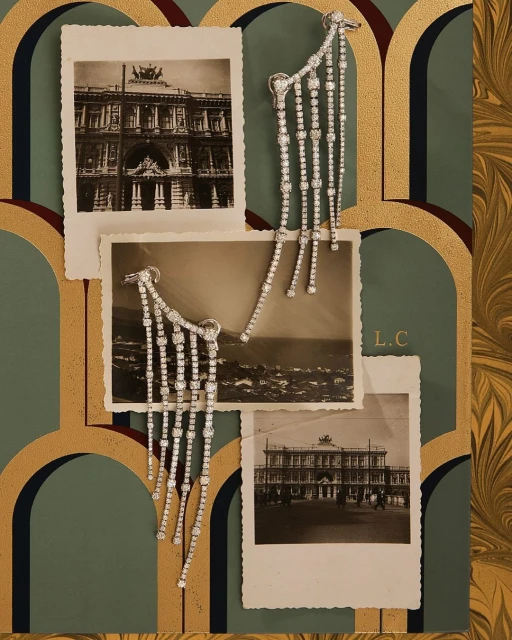 Elegant diamond fringe earrings displayed with black and white architectural photographs and ornate decorative art nouveau-inspired wallpaper.