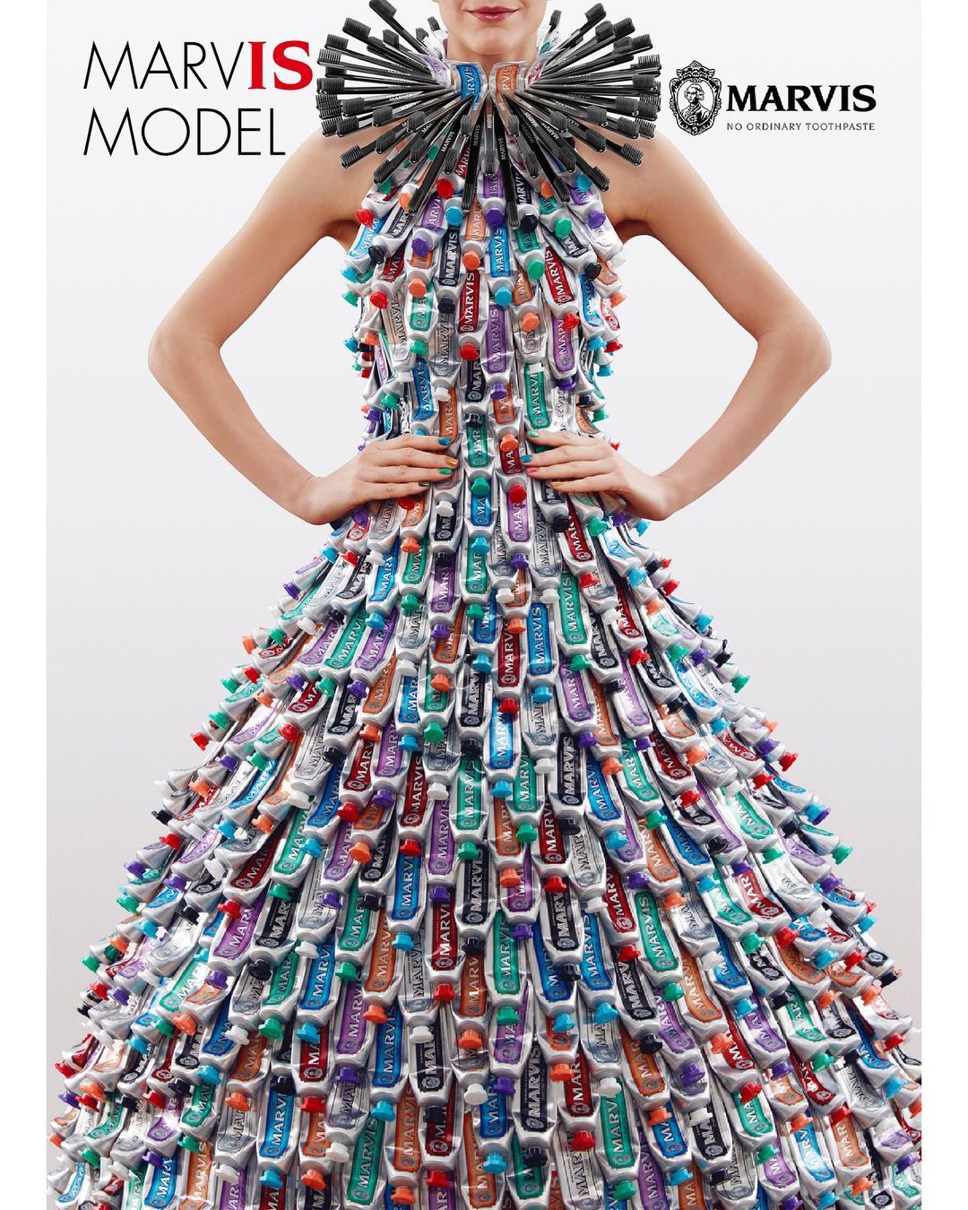 Model wears a dress and collar constructed from Marvis toothpaste tubes in a fashion editorial against a clean white backdrop.