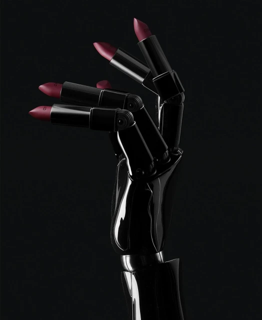 Black robotic hand holding three red lipsticks in a dark studio environment, showcasing beauty and technology integration with dramatic lighting.