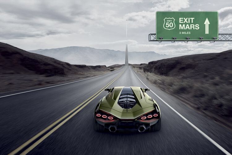 Green sports car drives along a long desert road toward the horizon, a sign reads 'Exit Mars' on an overcast day.