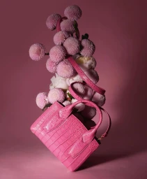 Pink textured leather handbag suspended with pale pink chrysanthemum and peony flowers on pink