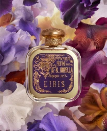 Square perfume bottle with ornate label surrounded by purple and white iris flower petals