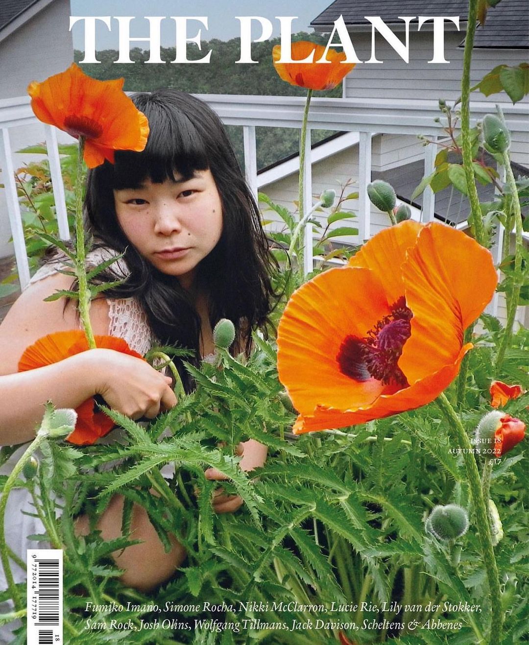 Magazine cover featuring a young adult woman surrounded by orange poppies and green foliage, photographed outdoors during daylight.