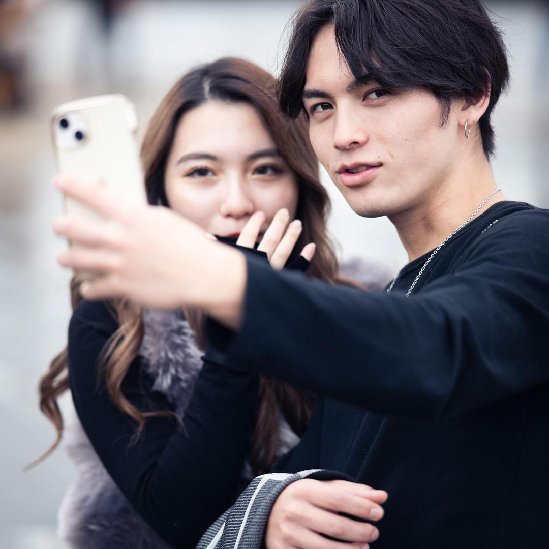 Young man and woman taking a selfie with a smartphone outdoors in Paris