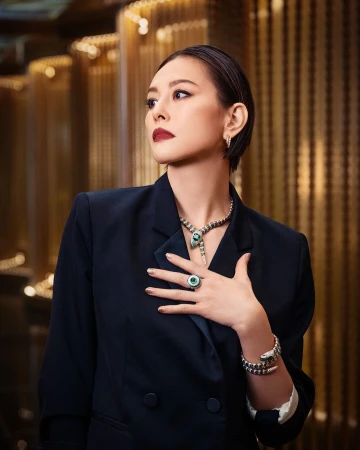 Woman with dark hair wearing a black blazer and snake necklace posing in Paris by Gabriel De La Chapelle
