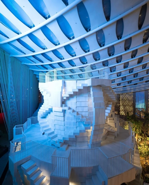 Unique architectural design featuring a white sculptural staircase in an interior space with a striking blue and white ceiling structure.