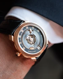 Close-up of a luxury BVLGARI watch with a black leather strap worn on a wrist in Paris