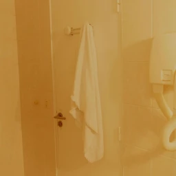 White towel hanging on a rack inside a tiled bathroom photographed by Gabriel Gomez in Paris