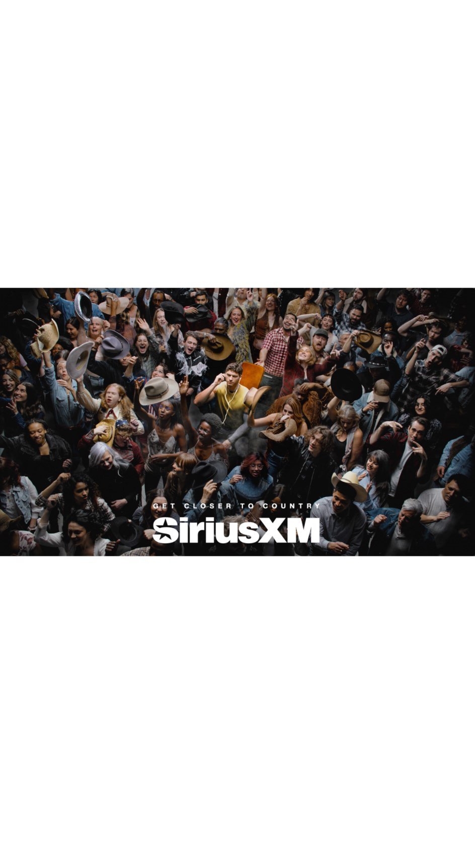 Energetic crowd of people raising hands and hats in celebration, possibly at a concert or event, with the SiriusXM logo visible.