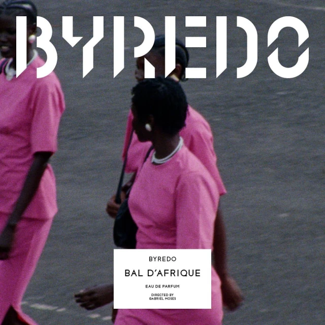 Three Black women wearing pink dresses walk on an urban street in a fashion or beauty context, with a Byredo perfume logo overlay.