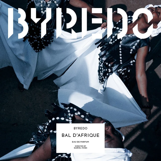 Elegant fashion shot featuring two women in white dresses with black seashell vests, promoting Byredo's Bal d'Afrique perfume.
