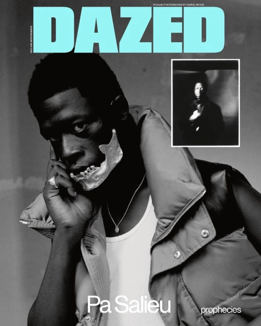 Magazine cover featuring African male in vest, white tank top, and prosthetic skull part over mouth, Dazed text logo at top.  