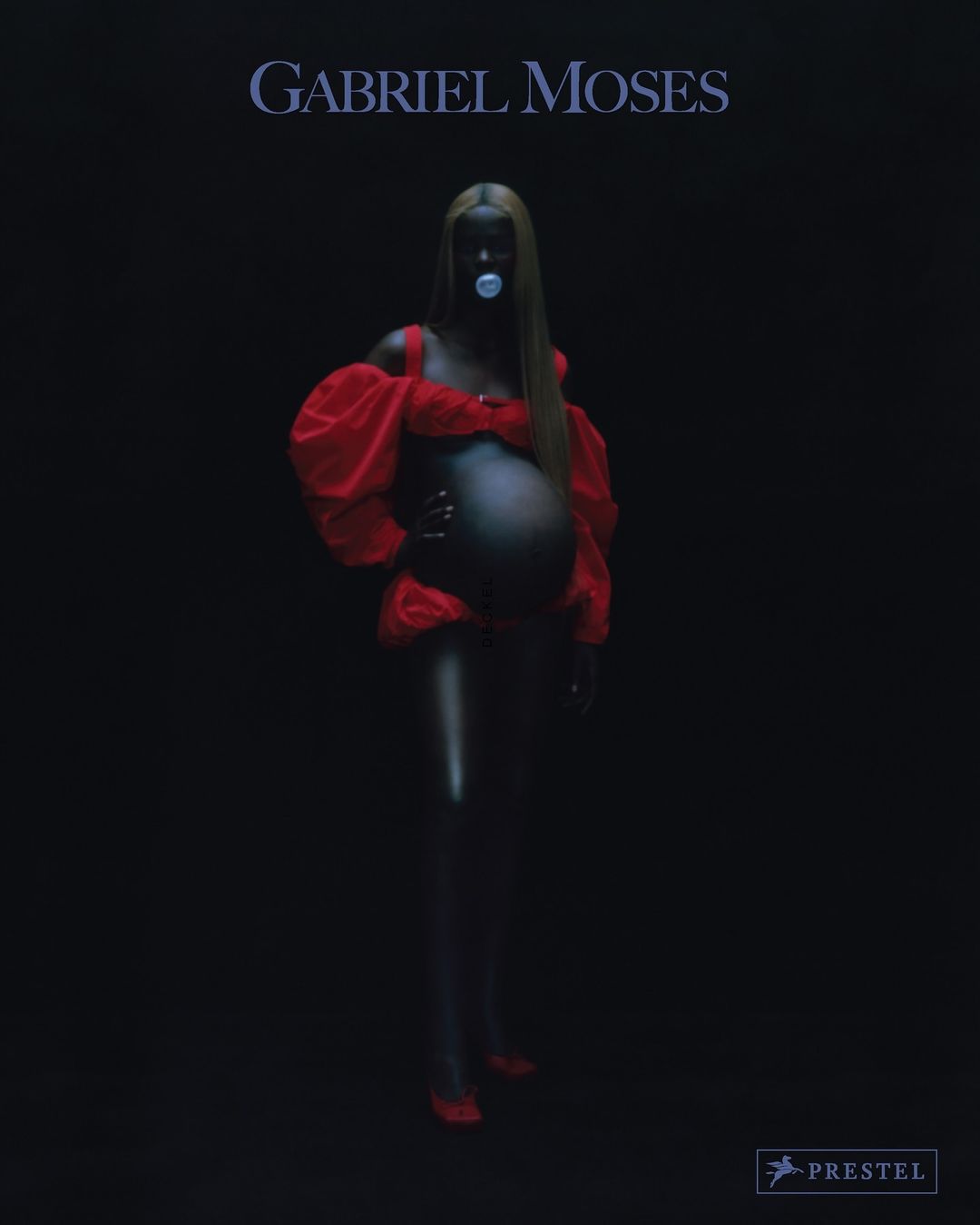Conceptual portrait of a pregnant Black female wearing a red outfit and a pacifier against a black background, promoting Gabriel Moses.