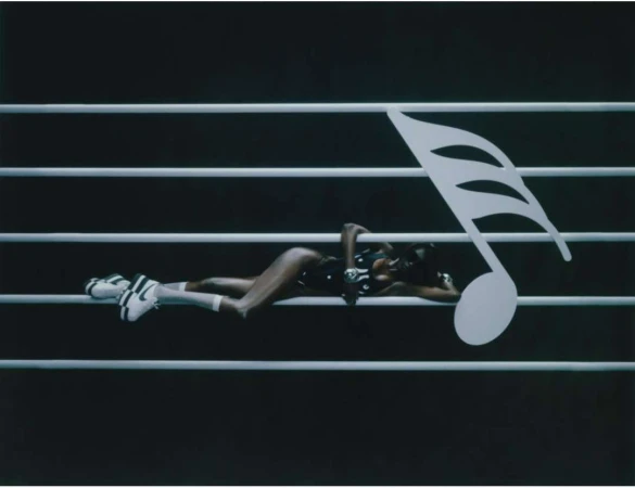 Woman in a bodysuit and sneakers reclines on a musical staff with a large eighth note in this fashion-music crossover scene.