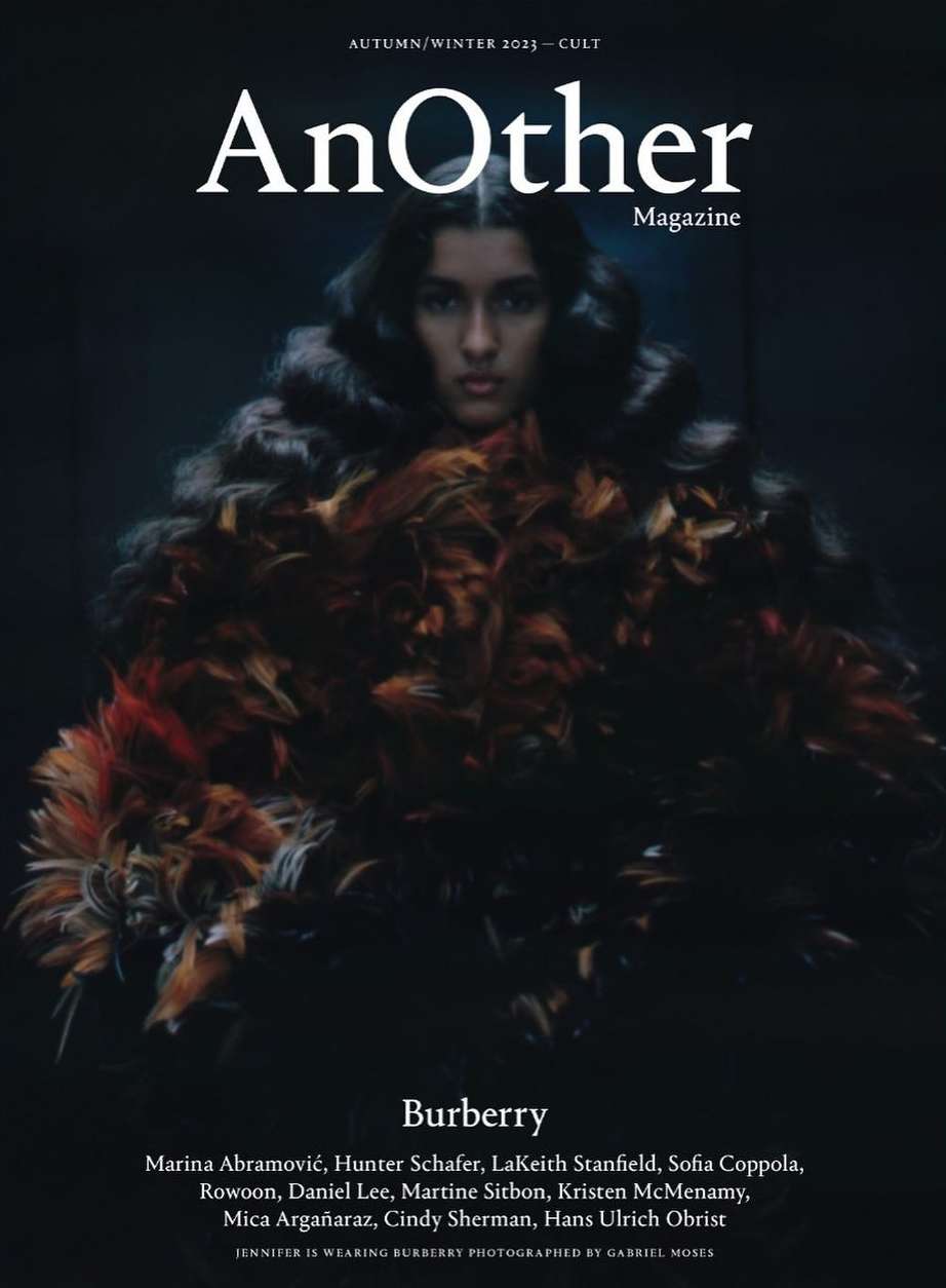 Magazine cover featuring a model wearing a feathery garment, with 'AnOther Magazine' and Burberry branding against a dark background.