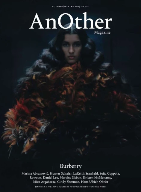 Magazine cover featuring a model wearing a feathery garment, with 'AnOther Magazine' and Burberry branding against a dark background.