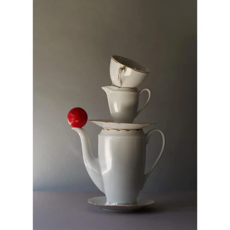 Still life of teaware and a red plum stacked on a gray gradient background in a vertical composition with good lighting and shadows.