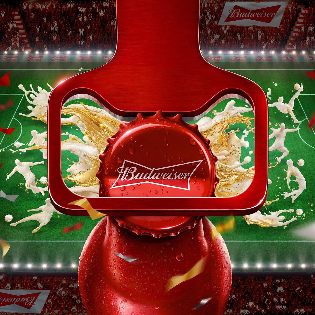A Budweiser beer advertisement with a bottle opener and bottle cap shown over a blurred soccer field and crowd setting.