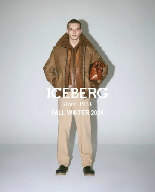 A male fashion model poses in a beige bomber jacket and trousers in a studio setting for Iceberg's Fall Winter 2024 collection.