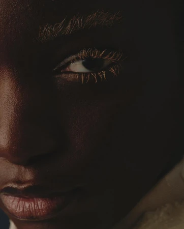 Close-up portrait of a Black model with bleached eyebrows and eyelashes by photographer Gautier Pellegrin in Milan