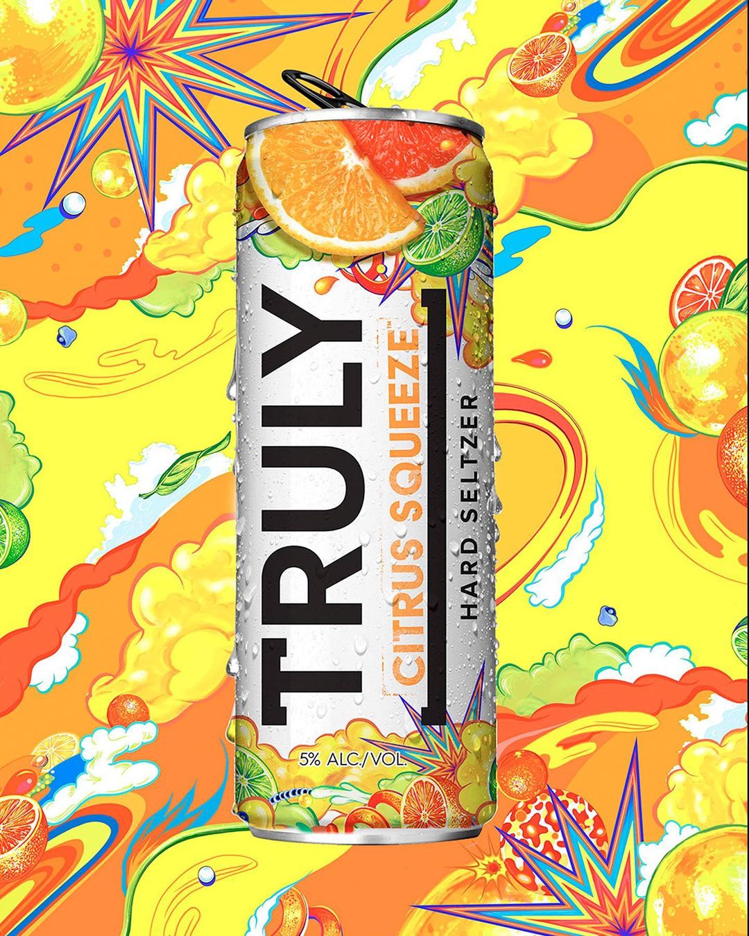 An aluminum can of Truly Citrus Squeeze Hard Seltzer with an orange wedge set against an abstract background of citrus-colored hues.