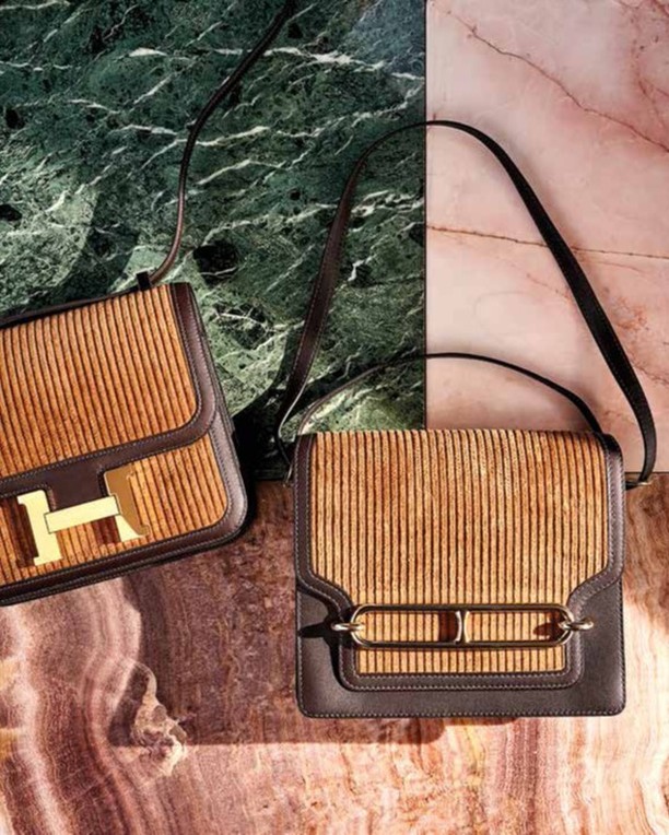 Two brown leather purses with golden hardware are displayed on a split green and pink marble backdrop, luxury fashion photography.