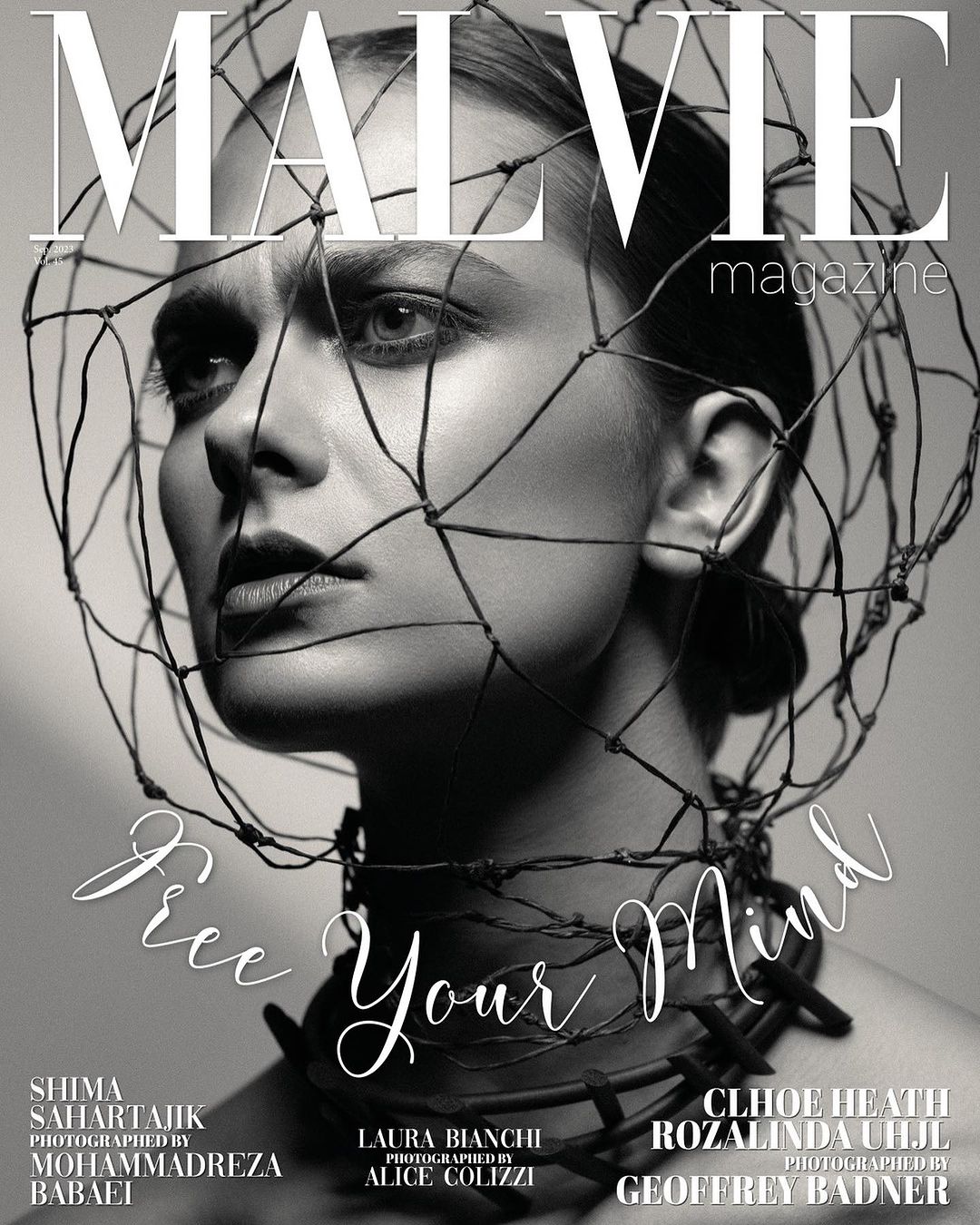 Black and white magazine cover featuring a woman with a wire cage headpiece, posing with a somber facial expression in a studio setting.