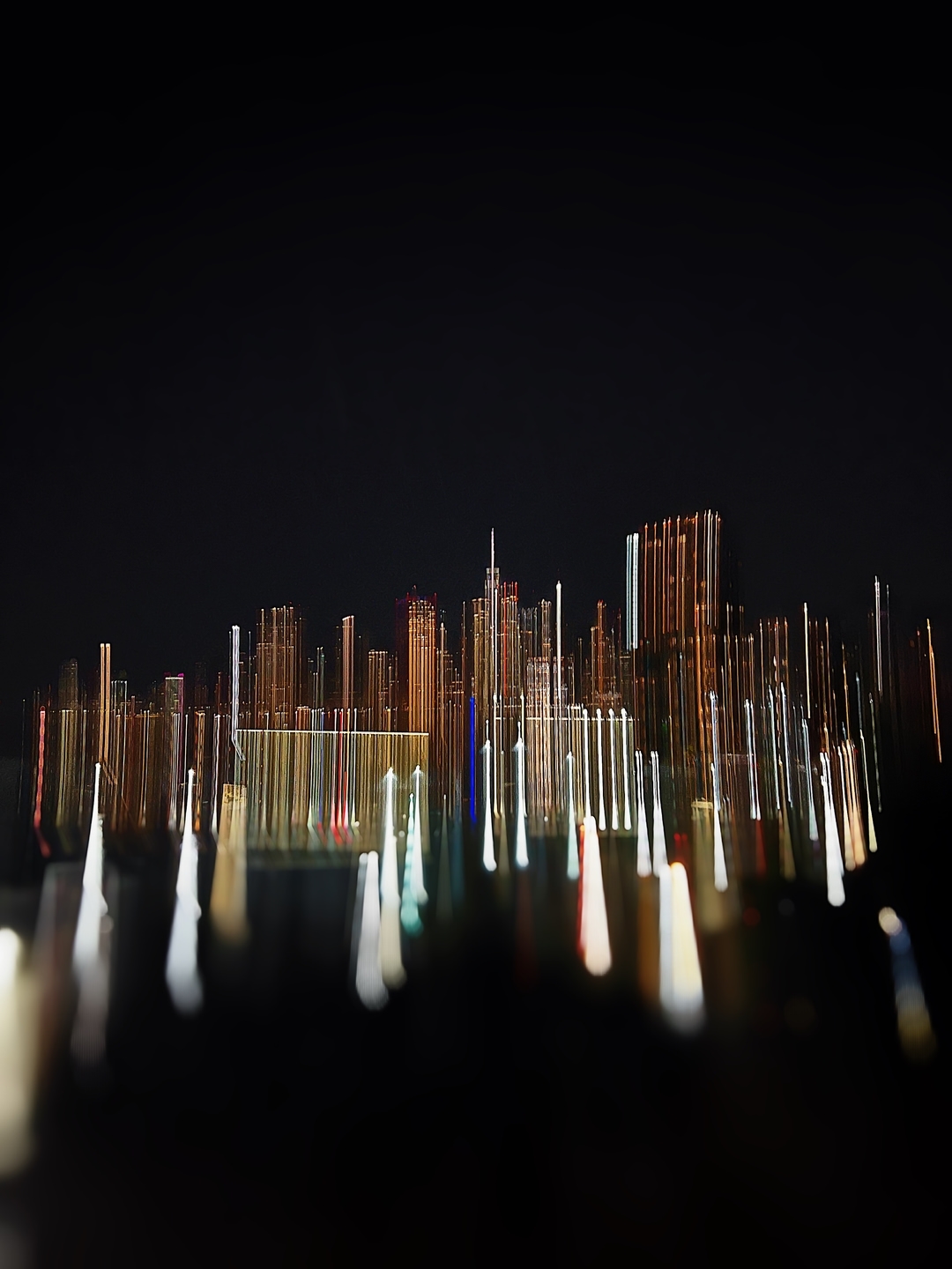 Abstract skyline at night features a blurred city view with illuminated buildings and light trails on a dark background.