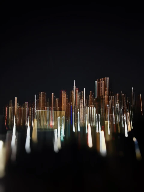 Abstract skyline at night features a blurred city view with illuminated buildings and light trails on a dark background.