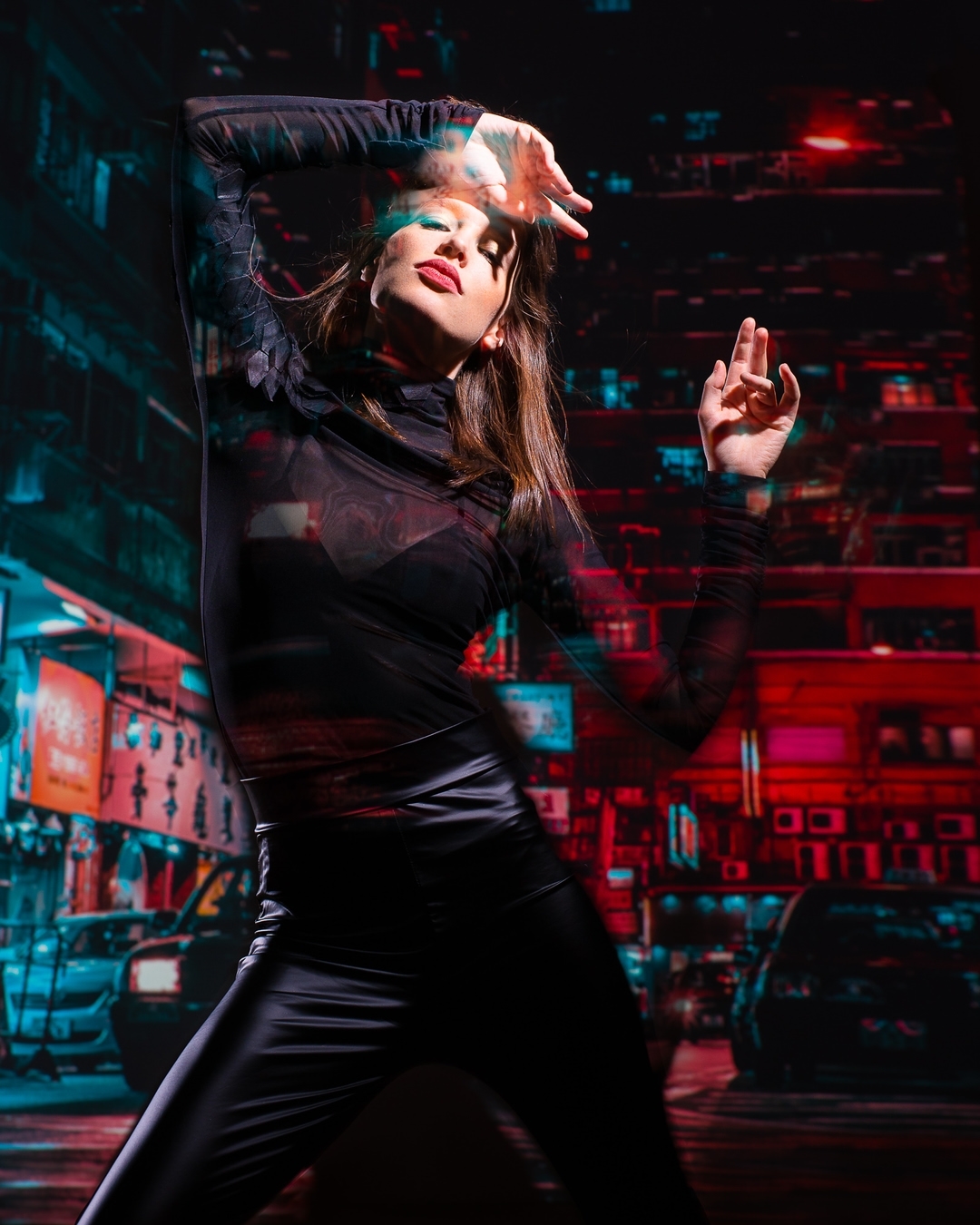 A woman in a black outfit poses dynamically against an urban backdrop with red and blue neon lighting, creating a modern, artistic vibe.