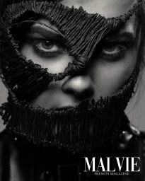 Close-up monochrome portrait of a person wearing a textured dark cord mask by photographer Geoffrey Badner.