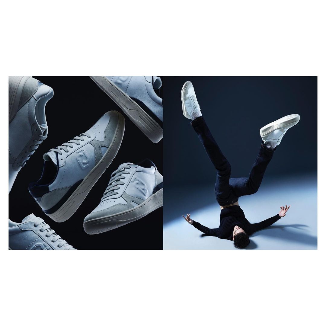 A split studio product shot showcases several light gray Fendi sneakers on a black backdrop next to a man balancing upside down on his head.