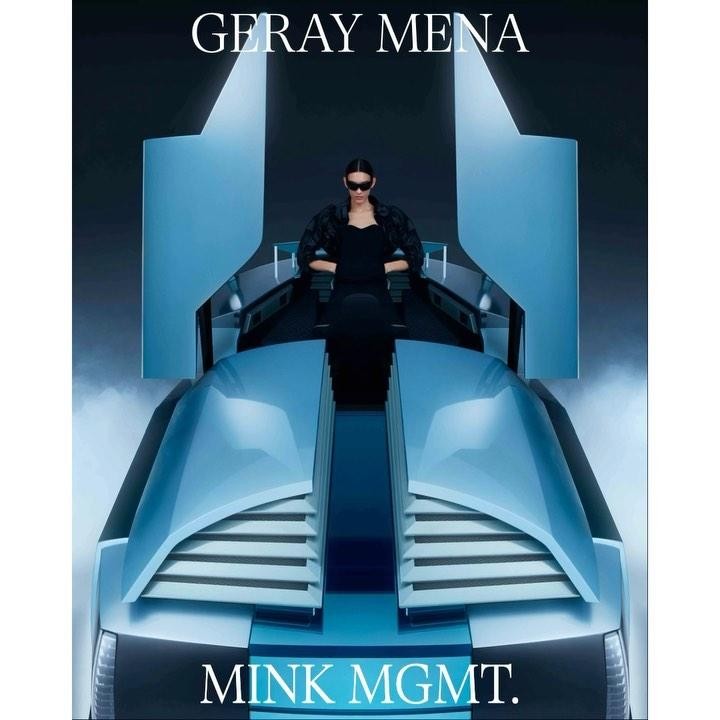 Woman in a black outfit and sunglasses sits in a light blue, futuristic-looking car against a dark gradient background in a studio shot.
