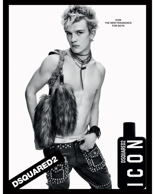 Black-and-white fashion shot features a young male model posing shirtless with studded pants and a fur accessory, plus a Dsquared2 Icon fragrance.