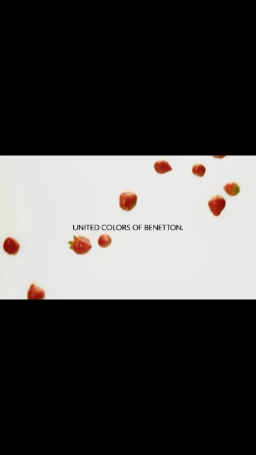 Scattered fresh strawberries and the UNITED COLORS OF BENETTON text logo set against a light background, creating a vibrant and playful food scene.