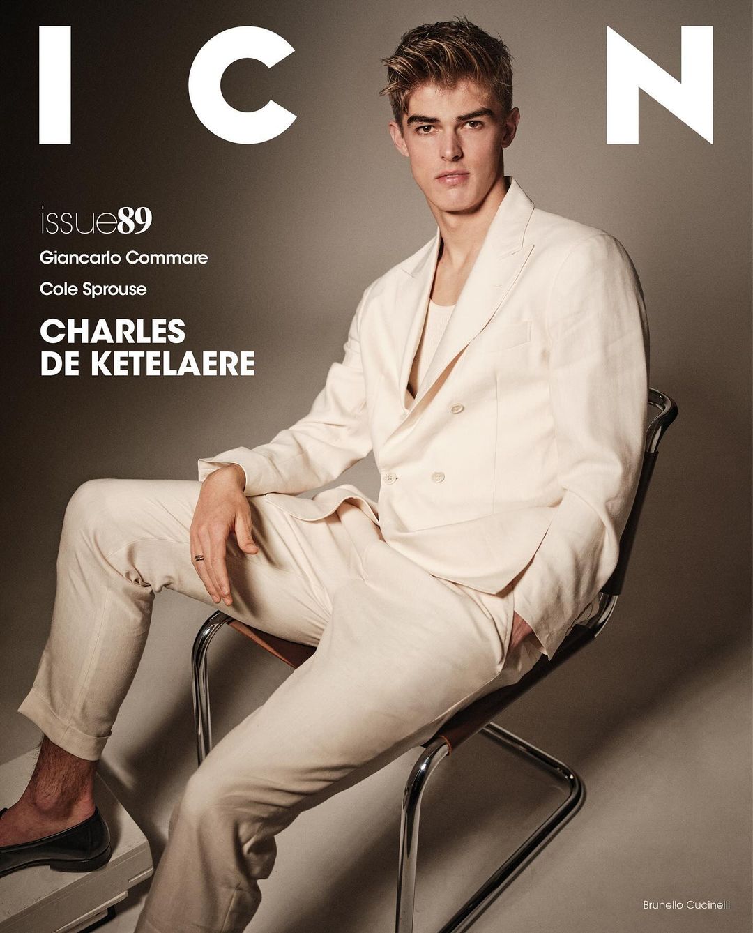 Magazine cover featuring a young adult male model in a cream-colored suit, sitting in a chair against a neutral backdrop with brand logos.