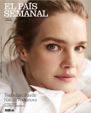 Close-up portrait of Natalia Vodianova with winged eyeliner wearing a white collared shirt against a neutral background