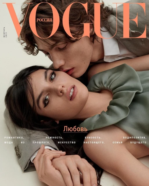 Vogue Russia cover featuring a close-up portrait of a young adult couple, the man kissing the woman's temple; warm skin tones, soft lighting.