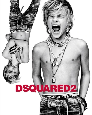 Black-and-white studio portrait of a screaming shirtless boy with blonde hair, jeans, jewelry, and the DSQUARED2 logo visible.