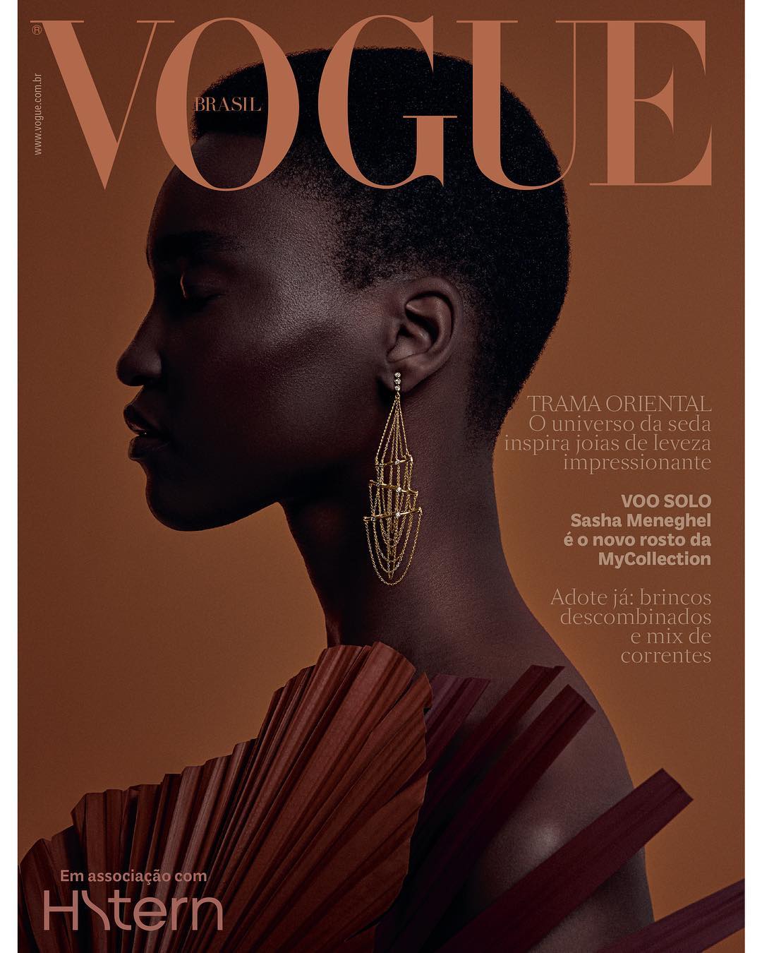 Vogue Brasil cover featuring a close-up profile of a Black female model with short hair, striking gold earrings, and a unique dress.