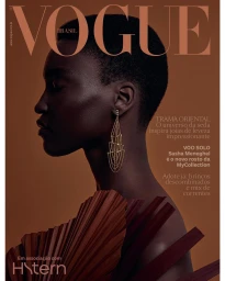 Profile portrait of a Black woman with short hair wearing a dangling gold earring and pleated collar by photographer Gil Inoue.