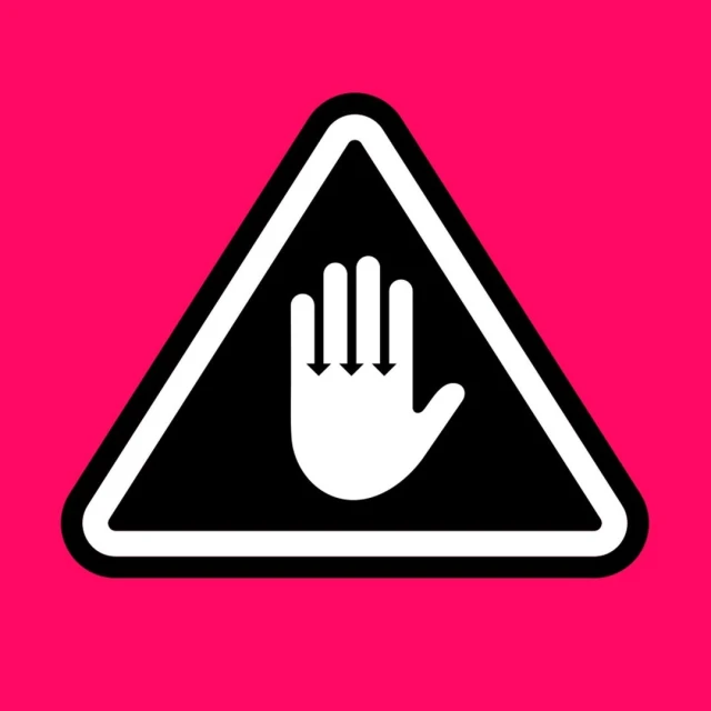 Warning sign with white hand graphic pointing downwards inside a black triangle on a hot pink background. Safety sign.