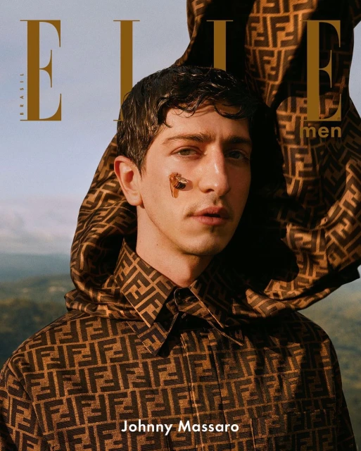 Elle Brazil magazine cover featuring a young man with a patterned jacket, posing outdoors with a sky and green trees background.