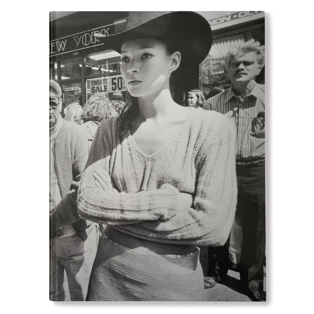 Black and white book cover features a woman in a hat among a crowd on a city street with buildings and storefronts behind them.