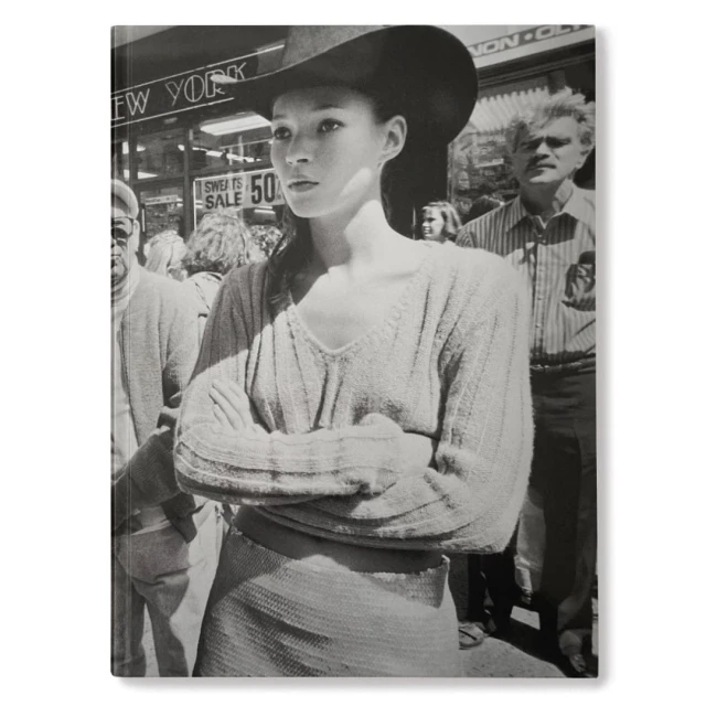 Black and white book cover features a woman in a hat among a crowd on a city street with buildings and storefronts behind them.