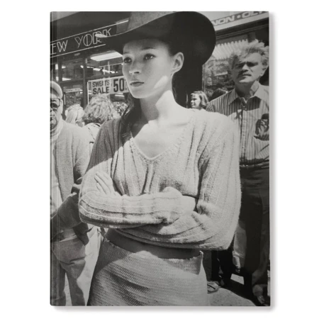 Black and white book cover features a woman in a hat among a crowd on a city street with buildings and storefronts behind them.
