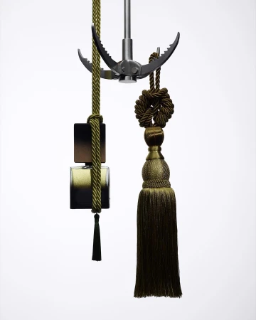 Conceptual display of a dark-toned perfume bottle suspended by decorative ropes and a metallic grappling hook against a bright white background.
