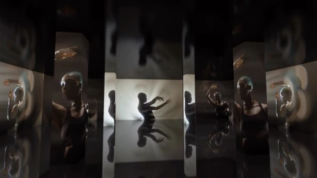 Reflective mirror installation featuring multiple distorted reflections of a person posing in a dark room