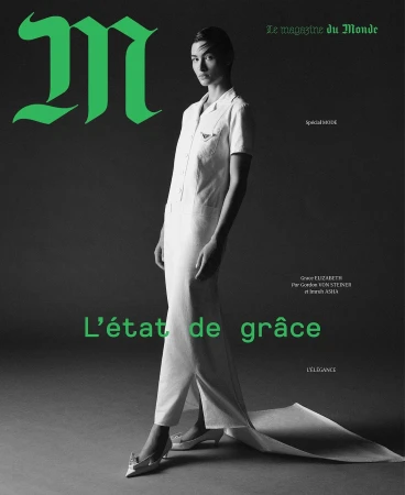 Magazine cover featuring a full-length shot of a slender female model in a white dress with green text and a grey background.
